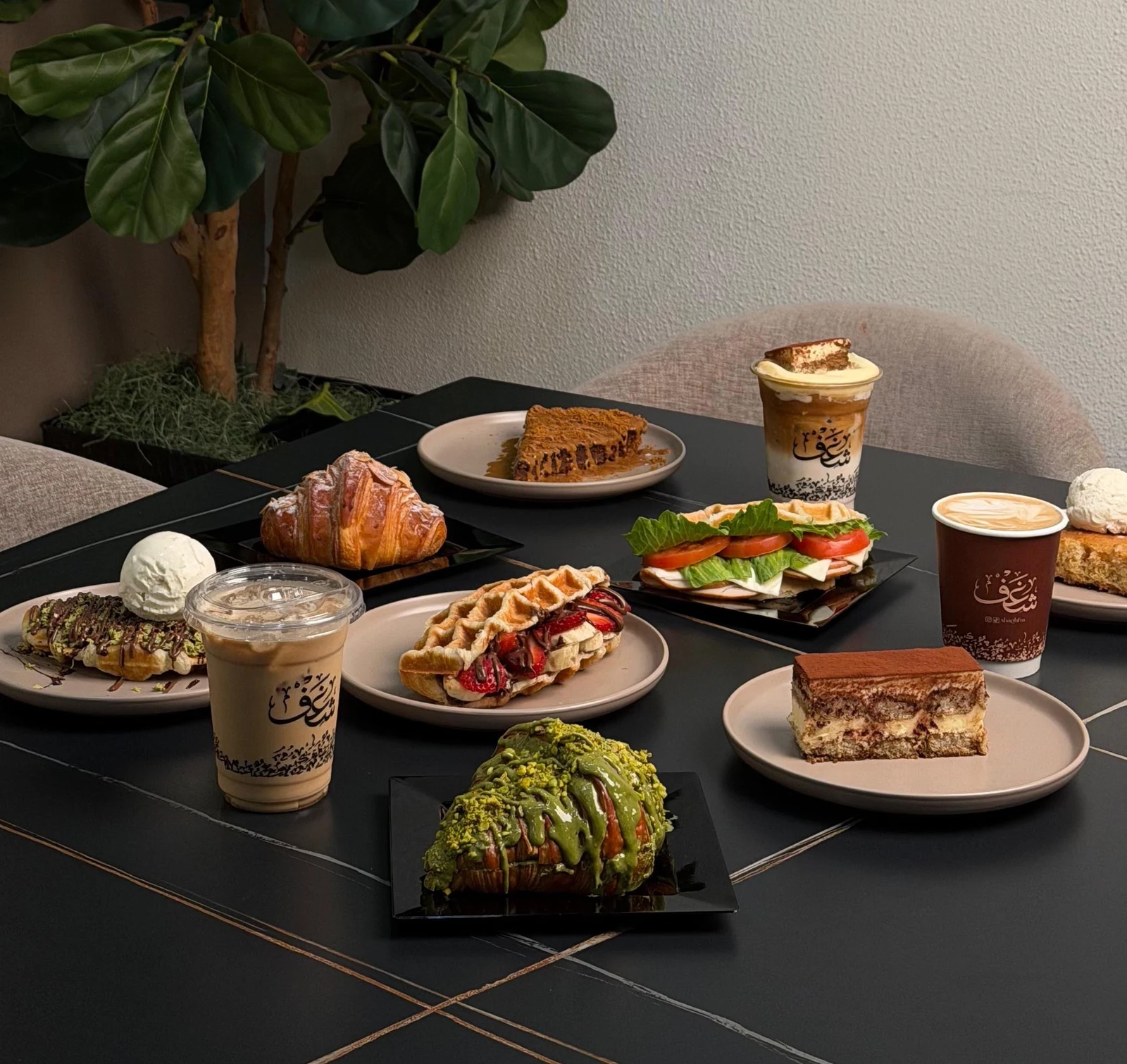 Shaghf coffee, croffles and desserts arranged on a café table